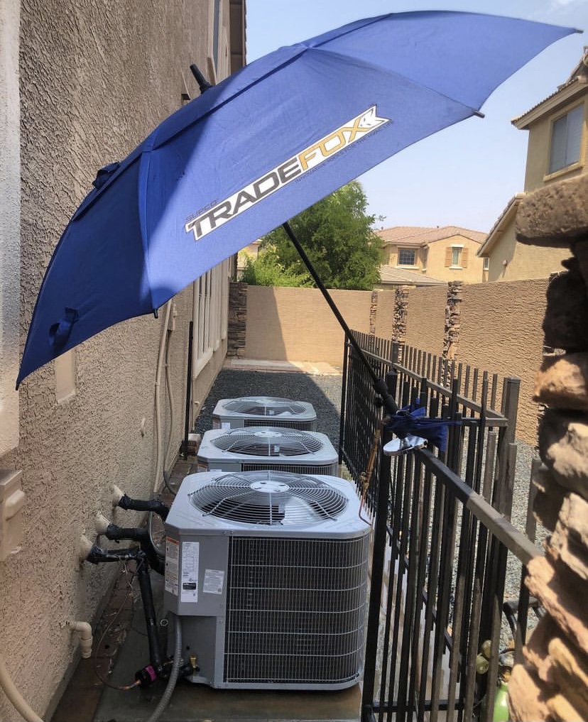 Three outdoor air-conditioning condensers installed beside a home