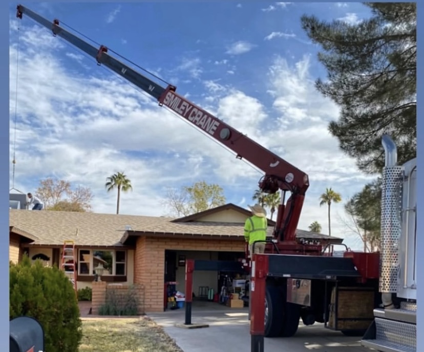 Crane lifting HVAC equipment above an Arizona home