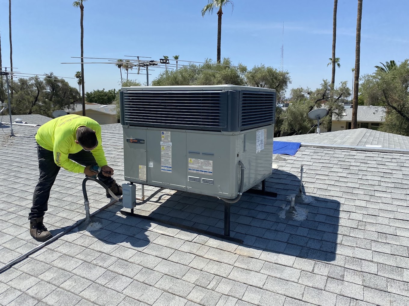 Technician servicing a rooftop air-conditioning unit